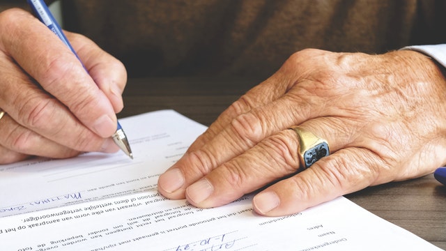 Close up of hands signing a document